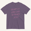 purple t-shirt with 'Today's a Good Day to Praise Jesus' pink text on a cream background