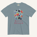 A slate blue crewneck t-shirt featuring a watercolor graphic of strawberries, blueberries, and blackberries with the text 'Berry Blessed' printed below in berry red, displayed on a light cream background.