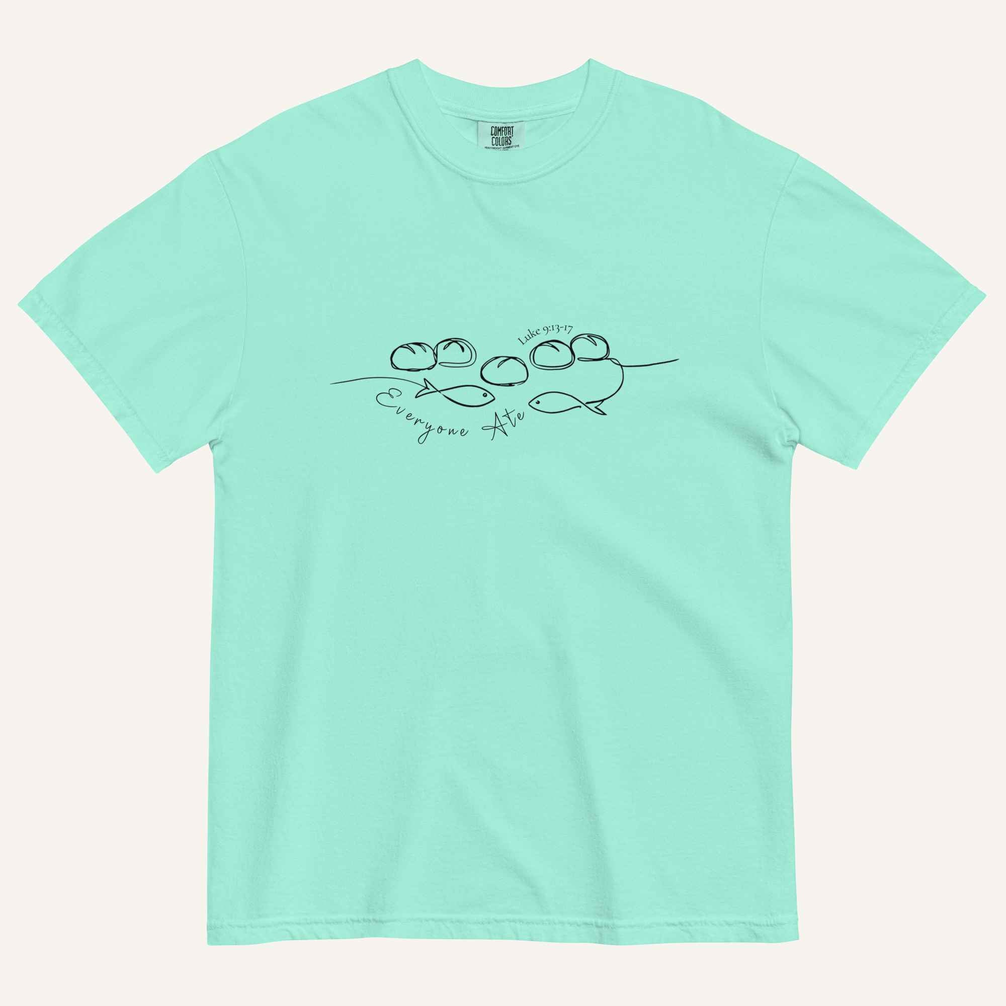 A mint blue/green short-sleeve crewneck t-shirt with a black graphic of two fish and 5 loaves of bread on a line and the cursive text 'Everyone Ate' across the chest, displayed flat against a light beige background.
