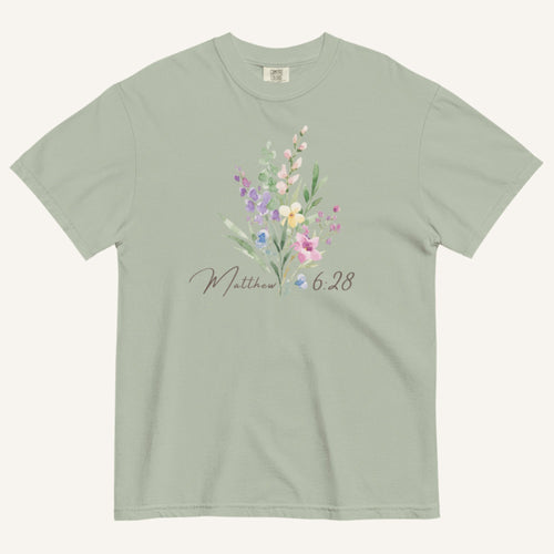 Green t-shirt with floral design and 'Matthew 6:28' text on a white background