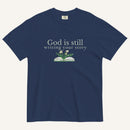 navy blue t-shirt with 'God is still writing your story' text and book graphic on a white background