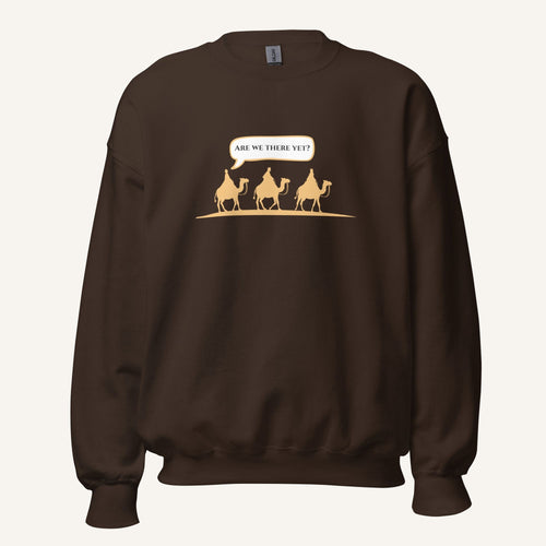 Dark brown unisex crewneck sweatshirt featuring a gold desert scene with three camels and a speech bubble reading “Are we there yet?”