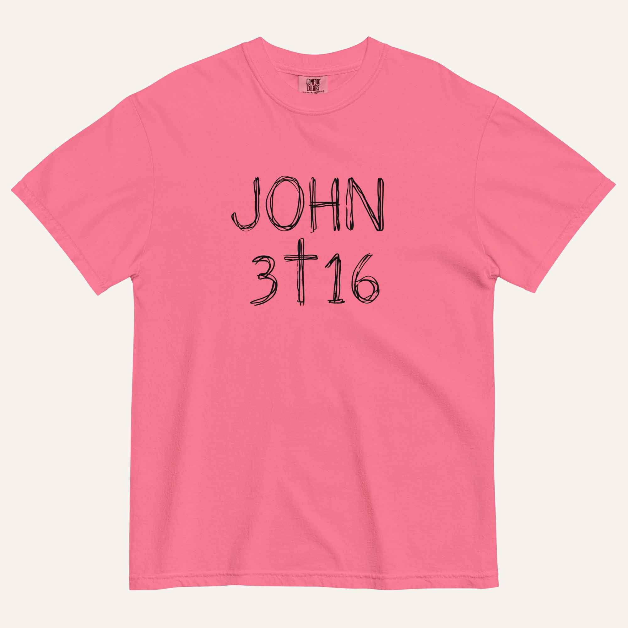 A hot pink short-sleeve crewneck t-shirt with 'JOHN 3 16' text with cross graphic in between the 3 & 16 printed in a black hand-drawn font on the chest, displayed flat against a light cream background.