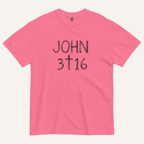 A hot pink short-sleeve crewneck t-shirt with 'JOHN 3 16' text with cross graphic in between the 3 & 16 printed in a black hand-drawn font on the chest, displayed flat against a light cream background.