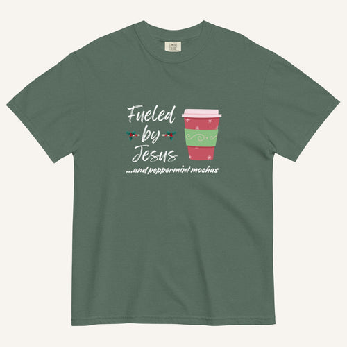Blue spruce Christmas T-shirt featuring the phrase “Fueled by Jesus …and peppermint mochas” with a festive peppermint mocha cup design.