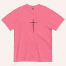A short-sleeve crewneck t-shirt in a pink color, featuring a simple black Christian cross printed on the center chest. The t-shirt is laid flat against a solid, warm off-white background.