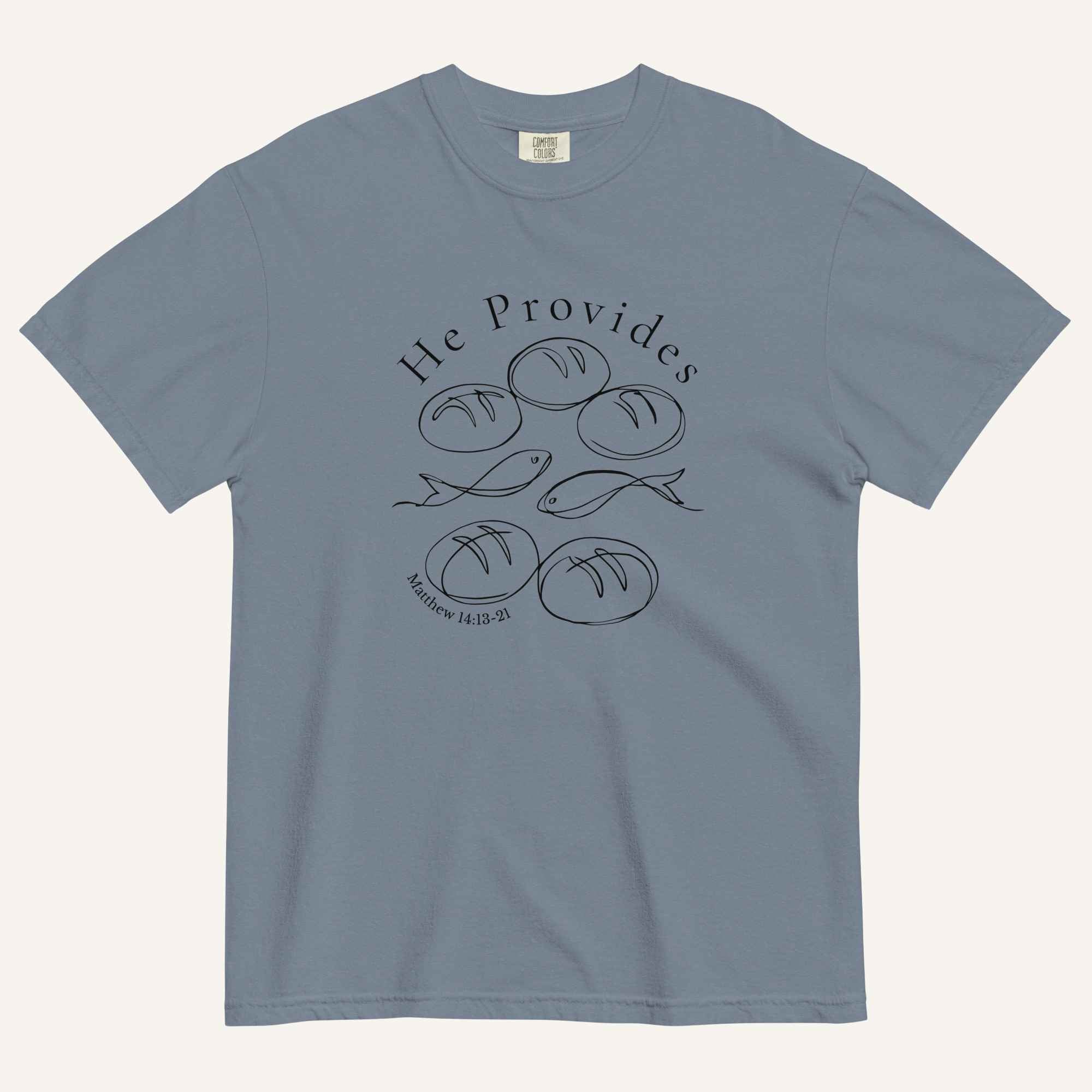 A muted blue short-sleeve t-shirt with a black graphic print on the front showing fish and loaves of bread, with the text 'He Provides' and 'Matthew 14:13-21'.