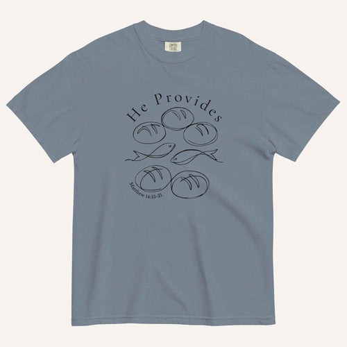 A muted blue short-sleeve t-shirt with a black graphic print on the front showing fish and loaves of bread, with the text 'He Provides' and 'Matthew 14:13-21'.
