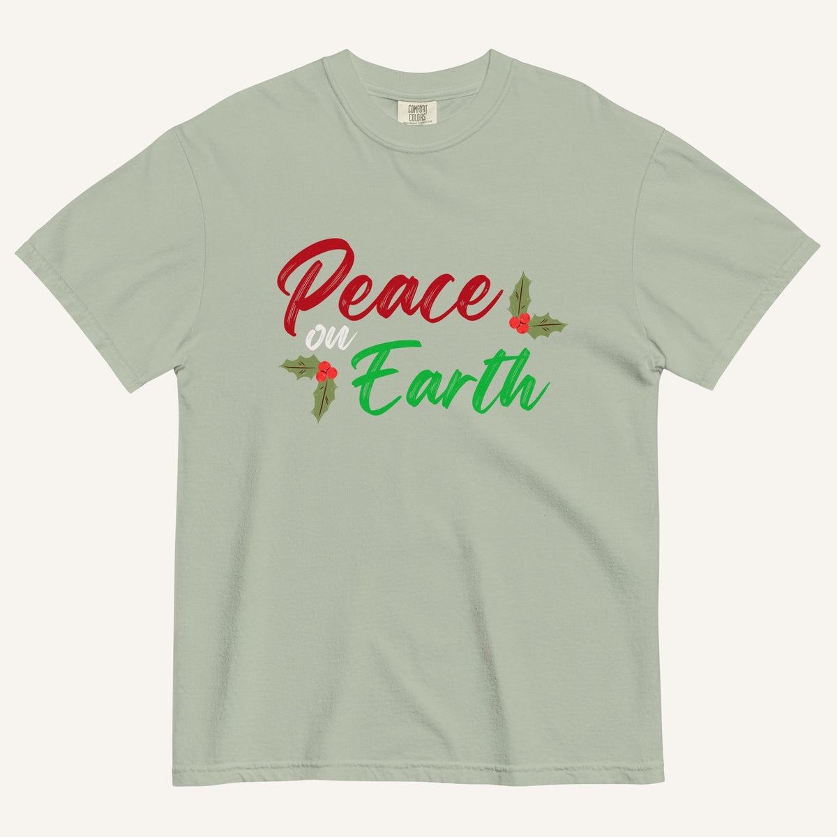 a muted sage green t-shirt with the text "Peace on Earth" and small botanical graphics