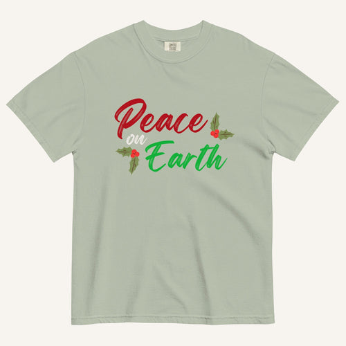 a muted sage green t-shirt with the text "Peace on Earth" and small botanical graphics