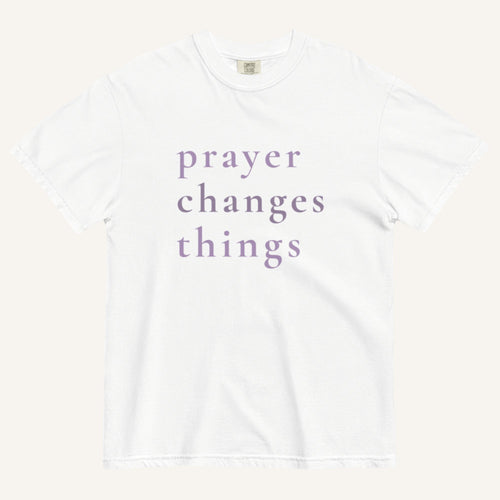 White t-shirt with 'prayer changes things' text in purple on a white background