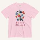 A light pink short-sleeve crewneck t-shirt featuring a colorful watercolor graphic of various berries (strawberries, blueberries, blackberries) and the text 'Berry Blessed' printed below it, displayed on a clean off-white background.