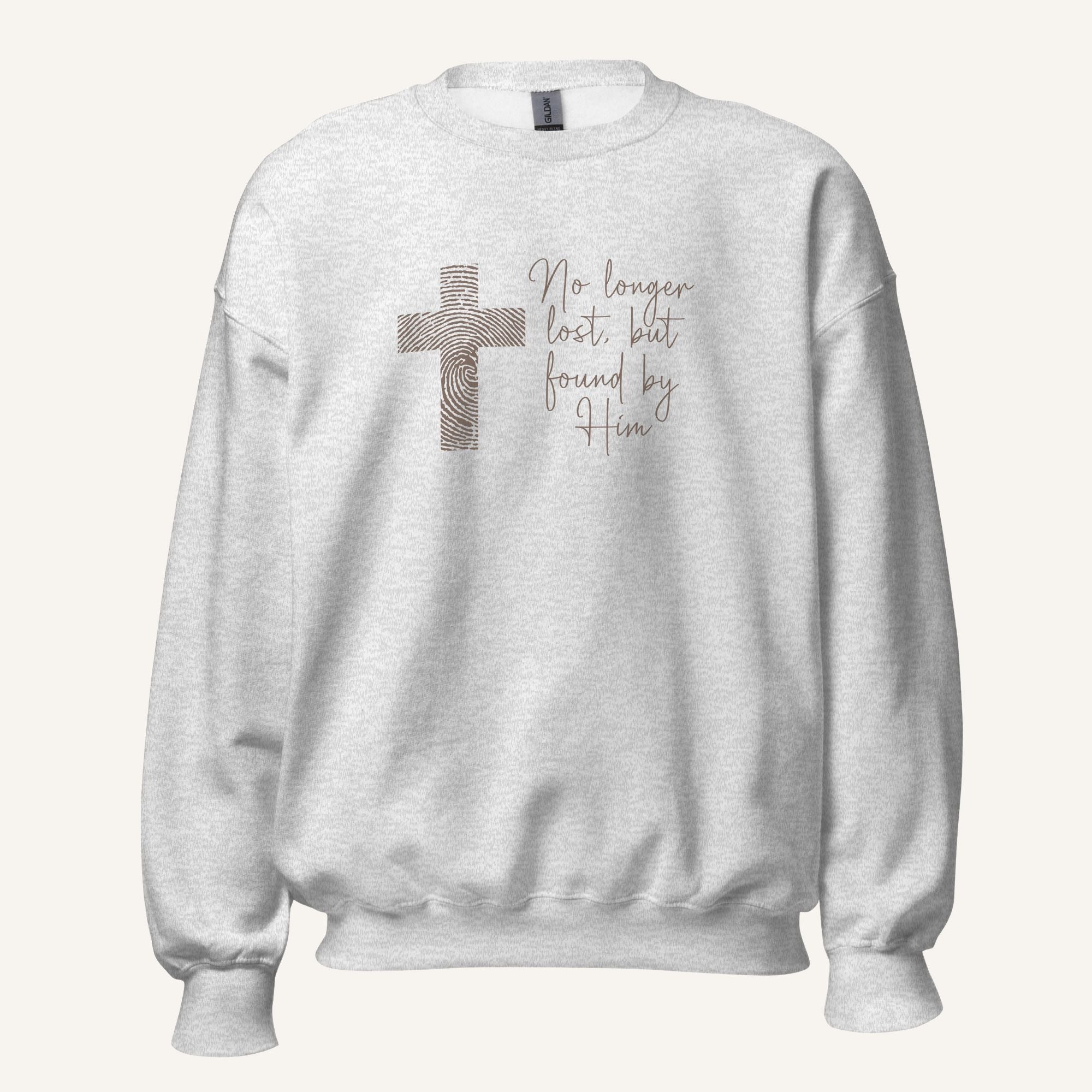 Ash grey sweatshirt with cross design and 'No longer lost, but found by Him' text on a cream background