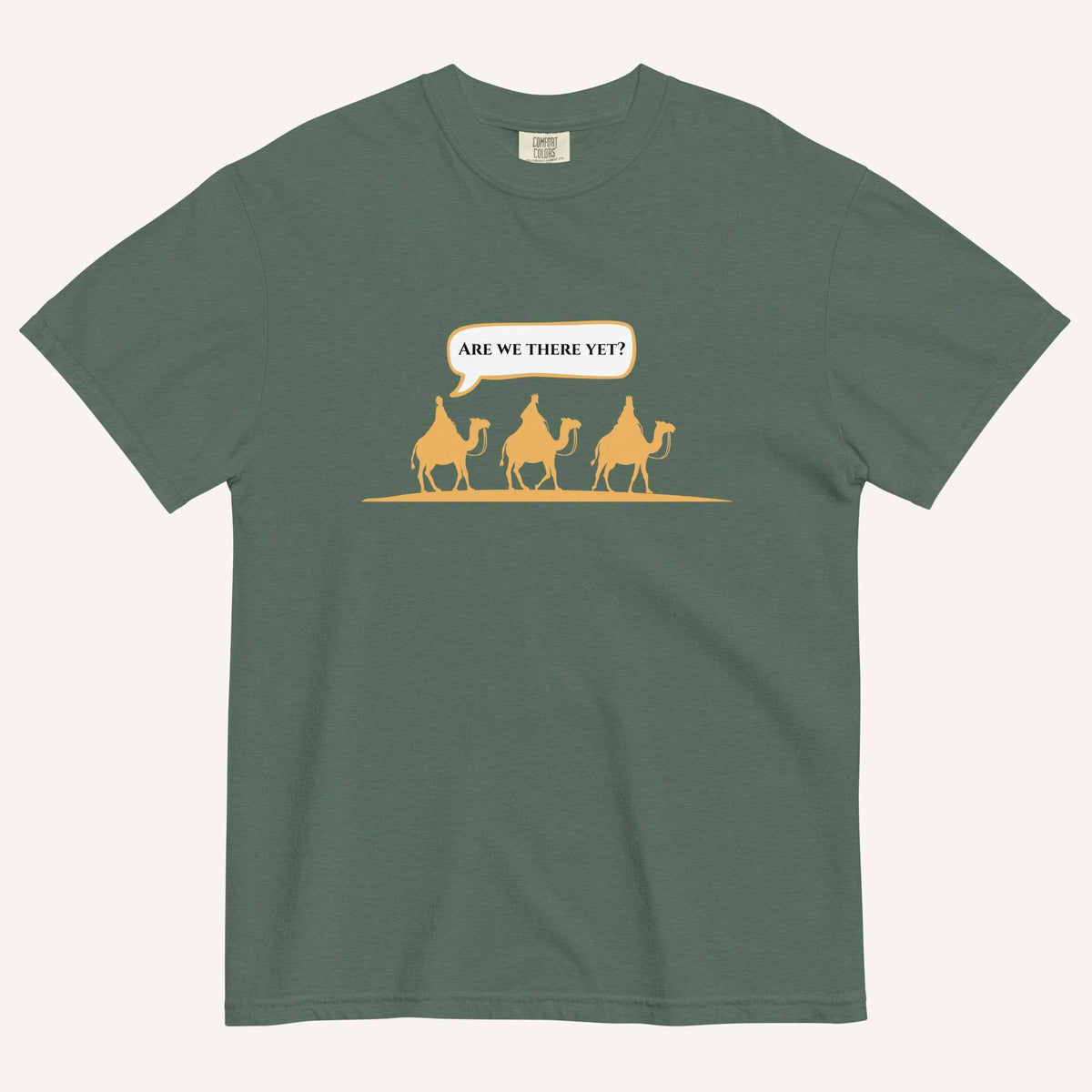 a muted dark green t-shirt with 3 men riding camels in the color yellow with a chat bubble with the text "are we there yet?"