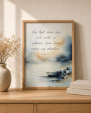 Framed artwork with a boat and text on a wooden surface with decor items.