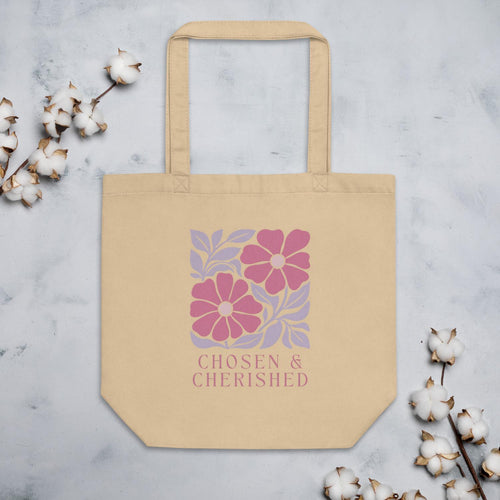 Beige tote bag with floral design and 'Chosen & Cherished' text on a light gray background with cotton branches.